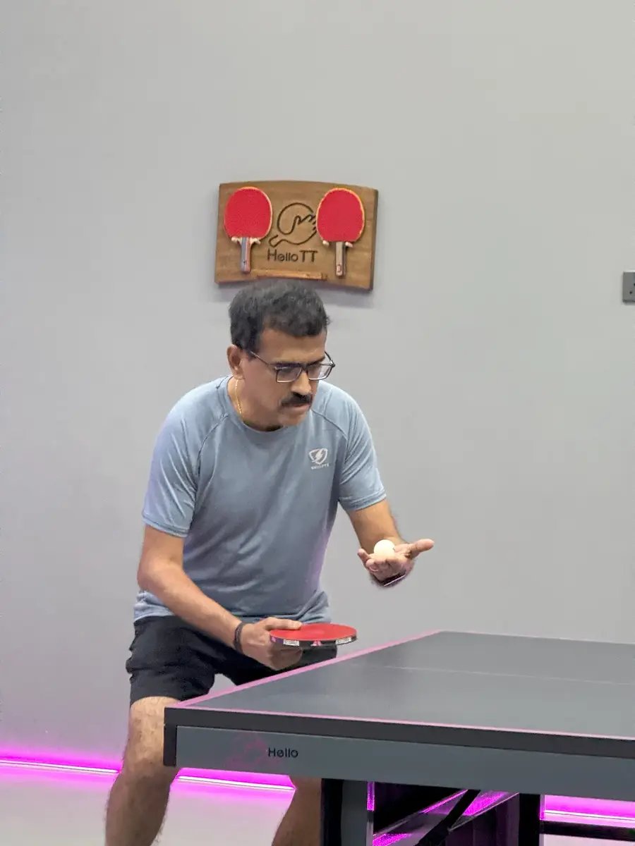 An adult player waiting for a serve